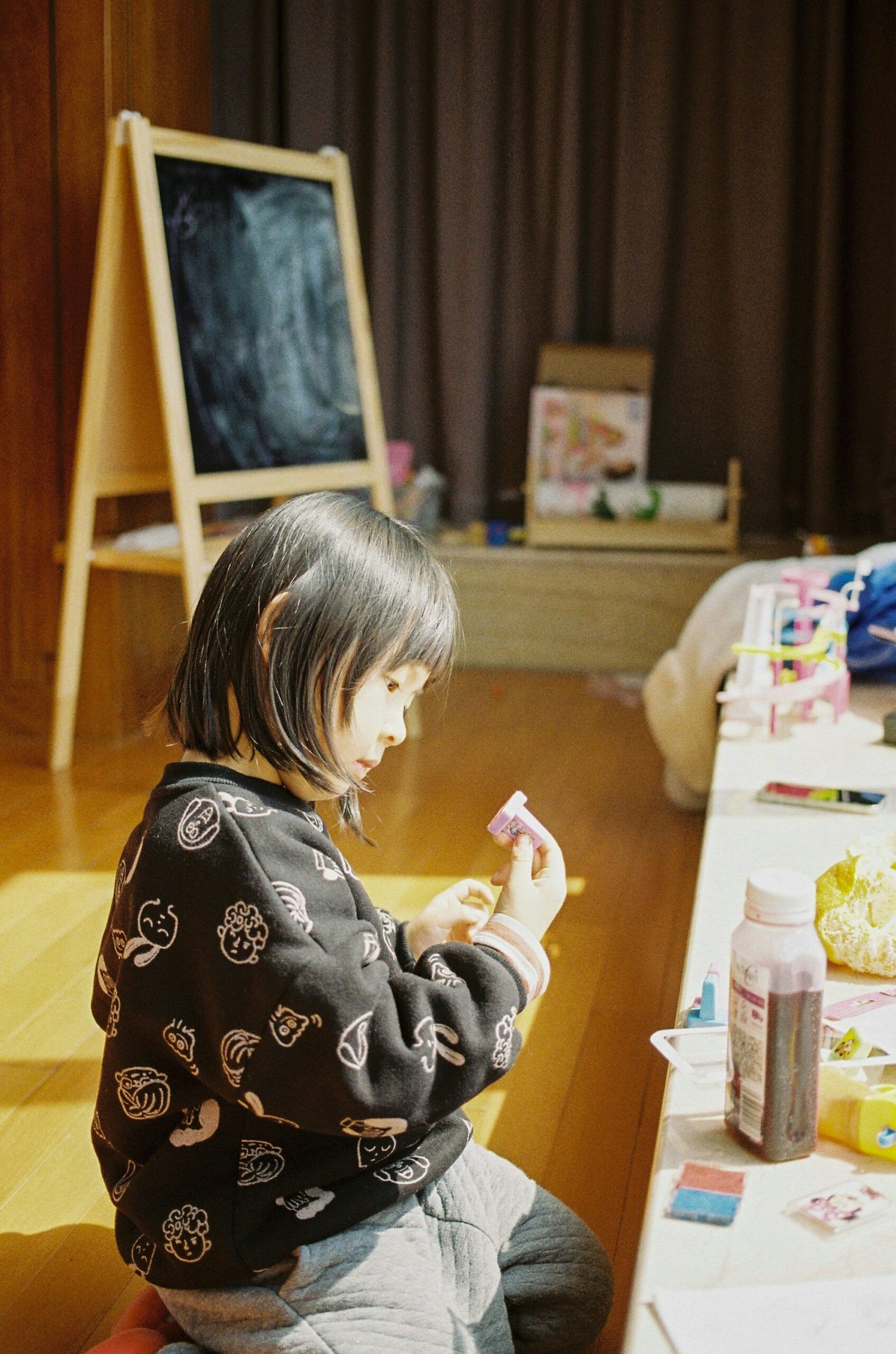 Bambina gioca con giocattoli in legno durante un laboratorio