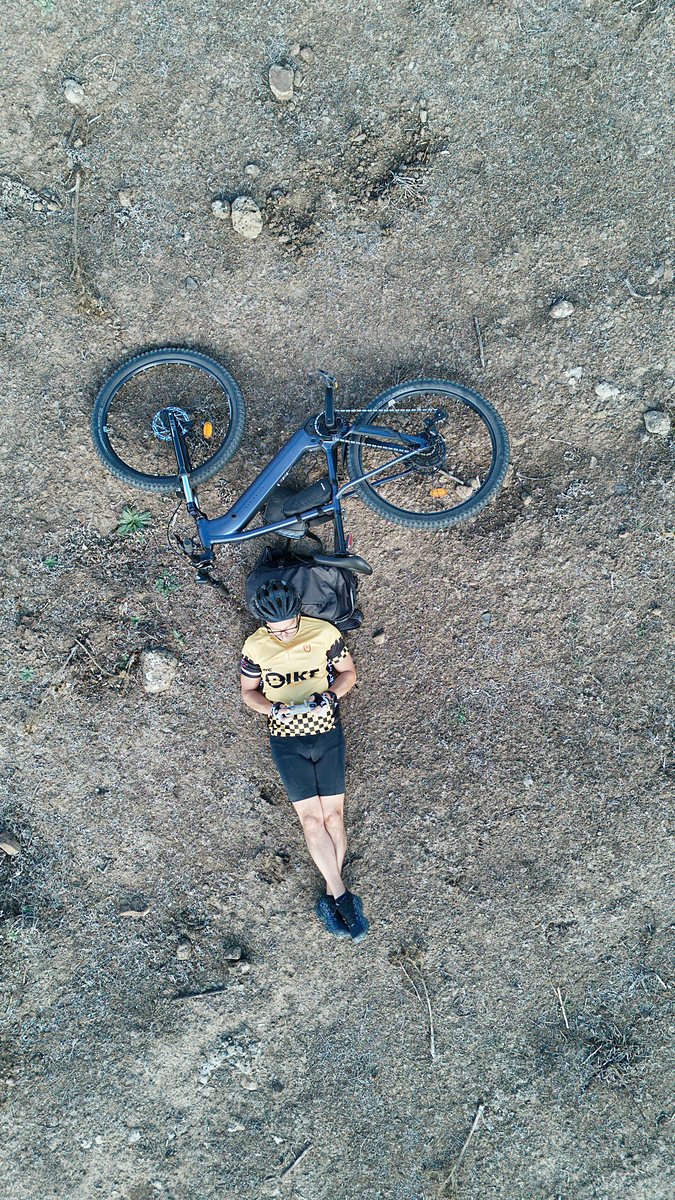 Ciclista in pausa accanto alla e-bike sulla Giara, ripresa dal drone